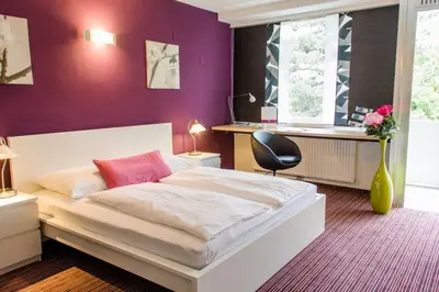 Ein Bett oder Betten in einem Zimmer der Unterkunft College Garden Hotel