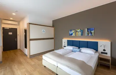 Ein Bett oder Betten in einem Zimmer der Unterkunft Hotel am See Rust