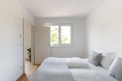 Ein Bett oder Betten in einem Zimmer der Unterkunft Grüne und zentrale Ruhelage im Neubau mit Balkon